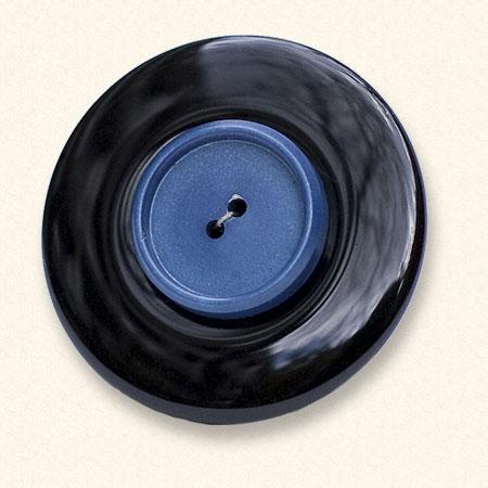 Ein Onyx-Trauerknopf mit dem blauen Knopf eines geliebten Menschen darauf. Der Onyx ist immer gleichmäßig schwarz.
