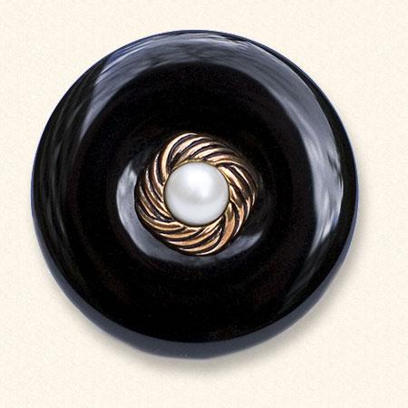Ein Onyx-Trauerknopf mit dem klassischen Knopf eines geliebten Menschen darauf. Der schwarze Onyx ist immer gleichmäßig gefärbt.